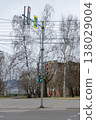 A traffic light on a pole on a sidewalk in the city. 138029004