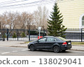 A black car is parked at the stop line on a city road. 138029041