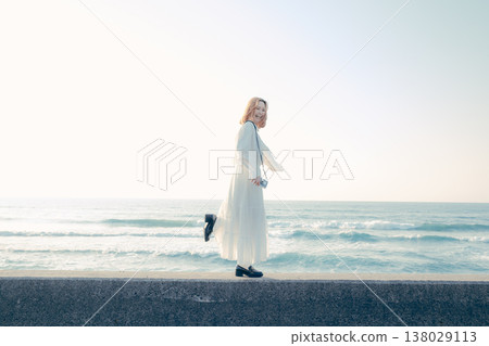 A young woman walking along the embankment 138029113