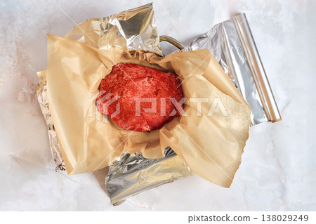 Cooked pork shoulder wrapped in paper and foil on a kitchen counter Cooked pork shoulder wrapped in paper and foil on a kitchen counter 138029249