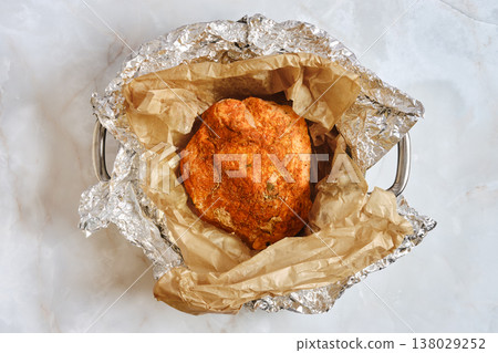 Cooking pork shoulder wrapped in foil with brown paper for flavor enhancement in the kitchen Cooking pork shoulder wrapped in foil with brown paper for flavor enhancement in the kitchen 138029252