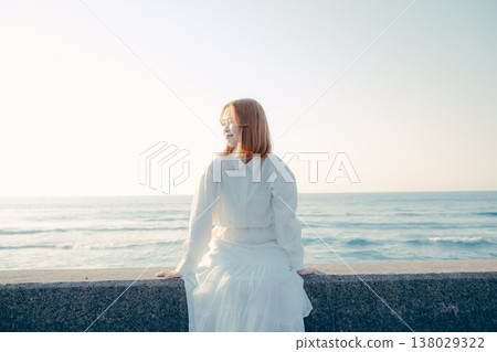 A young girl standing on the beach 138029322