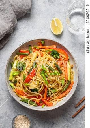Stir fry wok noodles with vegetables in a plate on a light background with chopsticks Stir fry wok noodles with vegetables in a plate on a light background with chopsticks 138029346
