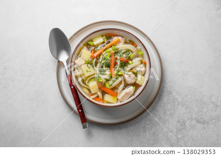 Chicken noodle soup with fresh dill in a bowl on a light textured background Chicken noodle soup with fresh dill in a bowl on a light textured background 138029353