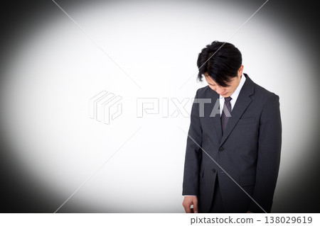 A dejected middle-aged businessman in a suit. 138029619