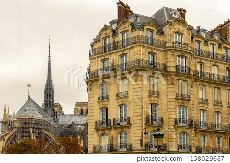 Restoring Notre Dame de Paris spire behind a classic Haussmann building, capturing European travel and history Restoring Notre Dame de Paris spire behind a classic Haussmann building, capturing European travel and history 138029687
