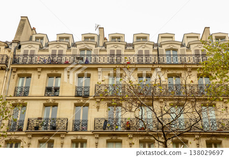 Parisian Haussmann building facade with French balconies, windows, and mansard roof in Paris, France 138029697