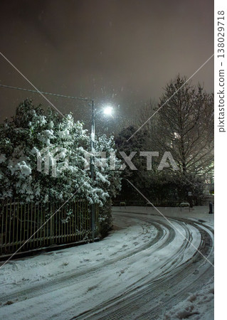 雪夜裡,居民區裡一條彎曲的道路 雪夜裡,居民區裡一條彎曲的道路 138029718