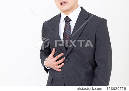 A middle-aged businessman in a suit suffering from pain in his right side. A middle-aged businessman in a suit suffering from pain in his right side. 138029756