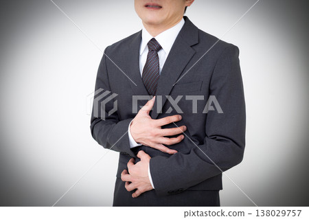 A middle-aged male businessman in a suit suffering from stomach pain A middle-aged male businessman in a suit suffering from stomach pain 138029757