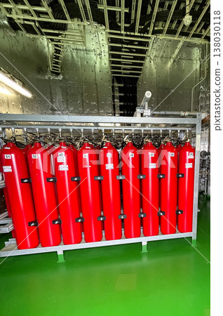 Bright red oxygen cylinders have been fitted aboard the vessel, standing out against the metal and machinery of the ship. Bright red oxygen cylinders have been fitted aboard the vessel, standing out against the metal and machinery of the ship. 138030118