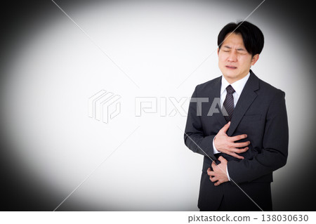 一位身著西裝的中年男性商人因胃痛 138030630