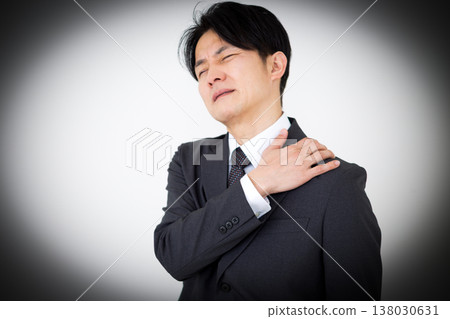 A middle-aged male businessman in a suit suffering from stiff shoulders 138030631