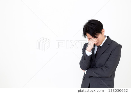 A dejected middle-aged businessman in a suit. 138030632