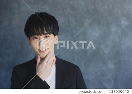 微笑一個年輕的人看照相機 微笑一個年輕的人看照相機 138030640