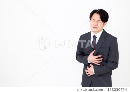 A middle-aged male businessman in a suit suffering from stomach pain A middle-aged male businessman in a suit suffering from stomach pain 138030734