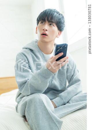 Men watching smartphones in bed Men watching smartphones in bed 138030781