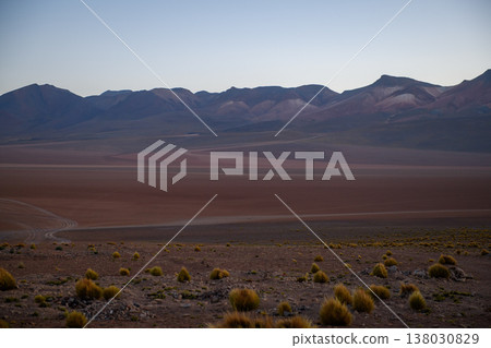 Serene and vast desert plain with mountain range at twilight Serene and vast desert plain with mountain range at twilight 138030829