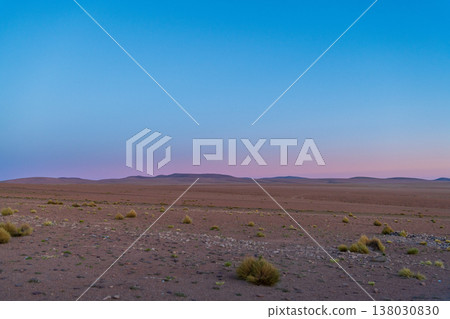 Serene desert landscape at twilight with colorful sky over vast mountain in South America Serene desert landscape at twilight with colorful sky over vast mountain in South America 138030830