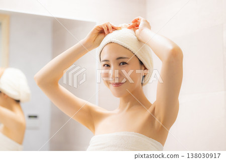 一位女士在浴室裡做頭髮護理。 一位女士在浴室裡做頭髮護理。 138030917