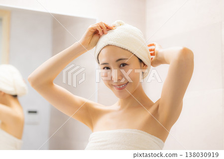 一位女士在浴室裡做頭髮護理。 一位女士在浴室裡做頭髮護理。 138030919