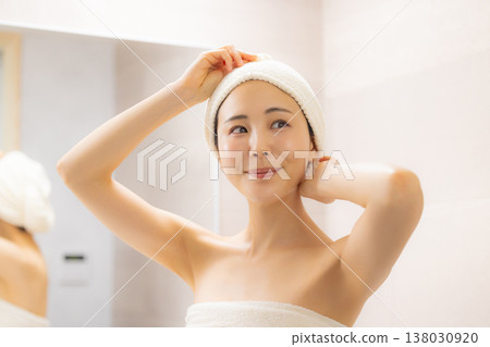 A woman doing hair care in the bathroom. A woman doing hair care in the bathroom. 138030920
