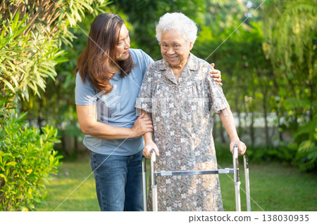 Asian elderly woman disability patient walk with walker in park. Asian elderly woman disability patient walk with walker in park. 138030935