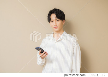 A young man looking at his smartphone 138031112