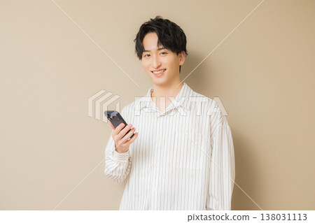 看他的智能手機的一個年輕人 看他的智能手機的一個年輕人 138031113