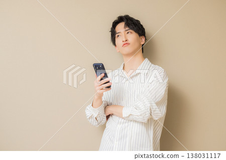 看他的智能手機的一個年輕人 看他的智能手機的一個年輕人 138031117
