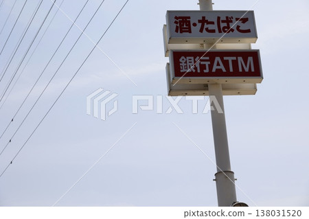 便利商店招牌上顯示著酒類、香菸和銀行自動櫃員機。 便利商店招牌上顯示著酒類、香菸和銀行自動櫃員機。 138031520