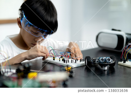 young boy having fun connecting electronic circuit board young boy having fun connecting electronic circuit board 138031636