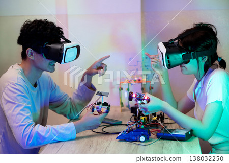 Young man and young woman amateur inventor testing electronic device model 138032250