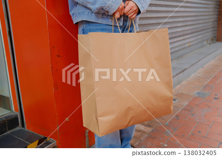 Woman holding kraft paper shopping bag standing on Hong Kong street steps urban casual lifestyle Woman holding kraft paper shopping bag standing on Hong Kong street steps urban casual lifestyle 138032405
