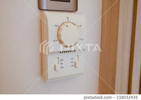 Vintage round analog thermostat temperature control dial mounted on wooden wall panel in Hong Kong interior Vintage round analog thermostat temperature control dial mounted on wooden wall panel in Hong Kong interior 138032438