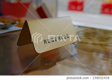 Reserved table tent card sign in restaurant closeup with blurred background in Hong Kong dining establishment Reserved table tent card sign in restaurant closeup with blurred background in Hong Kong dining establishment 138032439