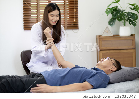 Asian young woman physiotherapist doing postures to cure and alleviate elderly Asian young woman physiotherapist doing postures to cure and alleviate elderly 138033348