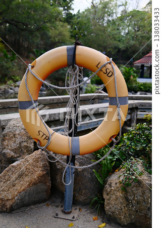 orange lifebuoy on fence in Hong Kong park safety equipment orange lifebuoy on fence in Hong Kong park safety equipment 138033433