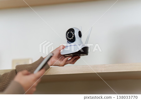 Smart home camera being adjusted on a shelf Smart home camera being adjusted on a shelf 138033770