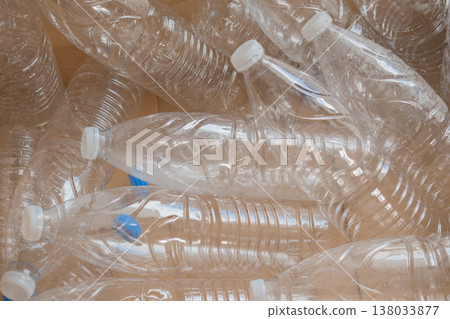 Clear plastic water bottles are packed in a cardboard box ready for recycling at a local facility Clear plastic water bottles are packed in a cardboard box ready for recycling at a local facility 138033877