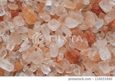 Macro view of coarse Himalayan pink salt crystals. All-over texture featuring diverse geometric shapes, peach to coral tones, and natural mineral patterns 138033880