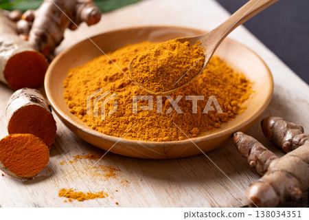 Turmeric powder and fresh turmeric roots on a wooden board. Organic healthy spice 138034351