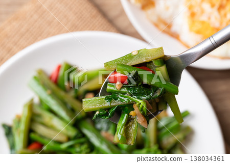 Stir-fried Chinese kale with soy sauce served with a fried egg on a white plate, Thai food style Stir-fried Chinese kale with soy sauce served with a fried egg on a white plate, Thai food style 138034361