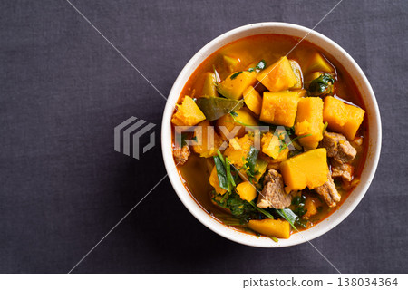 Thai spicy pumpkin curry soup with pork in a bowl on black background 138034364