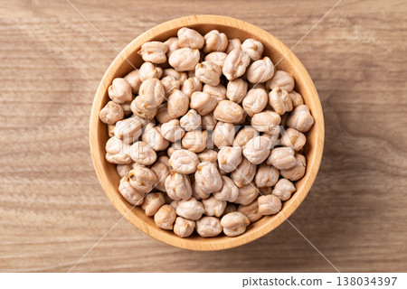 Organic raw chickpeas in a wooden bowl, healthy food ingredient, Table top view Organic raw chickpeas in a wooden bowl, healthy food ingredient, Table top view 138034397