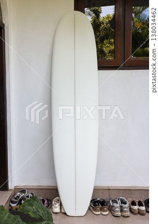 White surfboard leaning against wall near house entrance White surfboard leaning against wall near house entrance 138034462