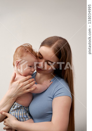 Loving embrace between mother and baby showcasing tenderness and connection in a serene environment highlighting nurturing relationships and family bonds concept 138034995