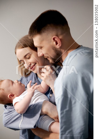Loving parents joyfully interacting with their newborn baby in a cozy home environment, showcasing the beauty of family bonding and nurturing moments, family love concept Loving parents joyfully interacting with their newborn baby in a cozy home environment, showcasing the beauty of family bonding and nurturing moments, family love concept 138035002