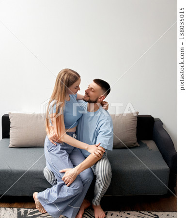 Couple sitting on a sofa while sharing a moment together in a cozy living room during daylight hours Couple sitting on a sofa while sharing a moment together in a cozy living room during daylight hours 138035015