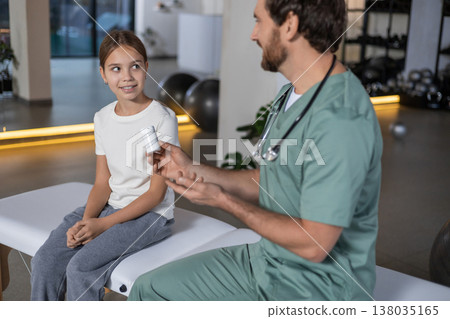 Doctor gesturing and talking about pills to young girl Doctor gesturing and talking about pills to young girl 138035165